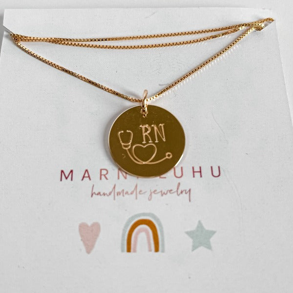 Gold stethoscope necklace with RN designation stamped on it
