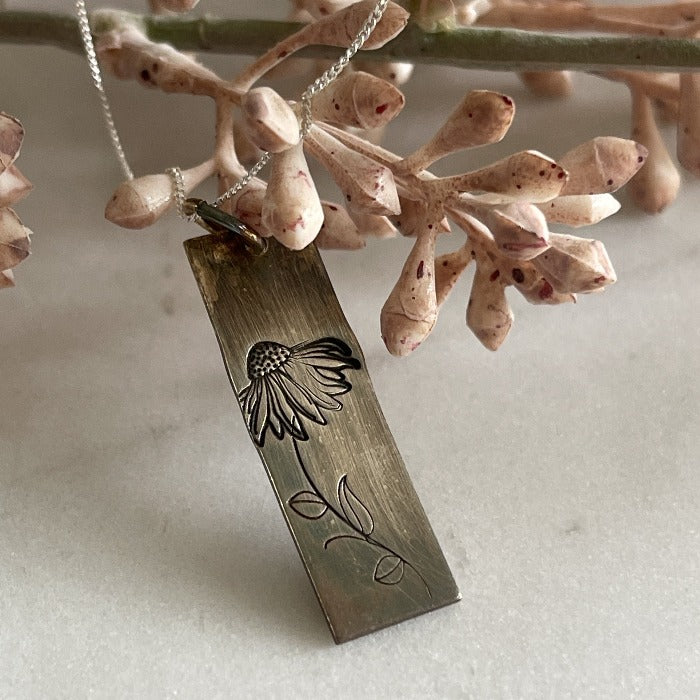 Hand-stamped coneflower stamped on a sterling bar and then oxidized on a silver chain