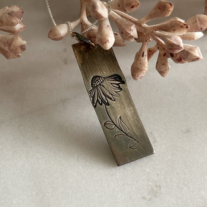 Hand-stamped coneflower stamped on a sterling bar and then oxidized on a silver chain