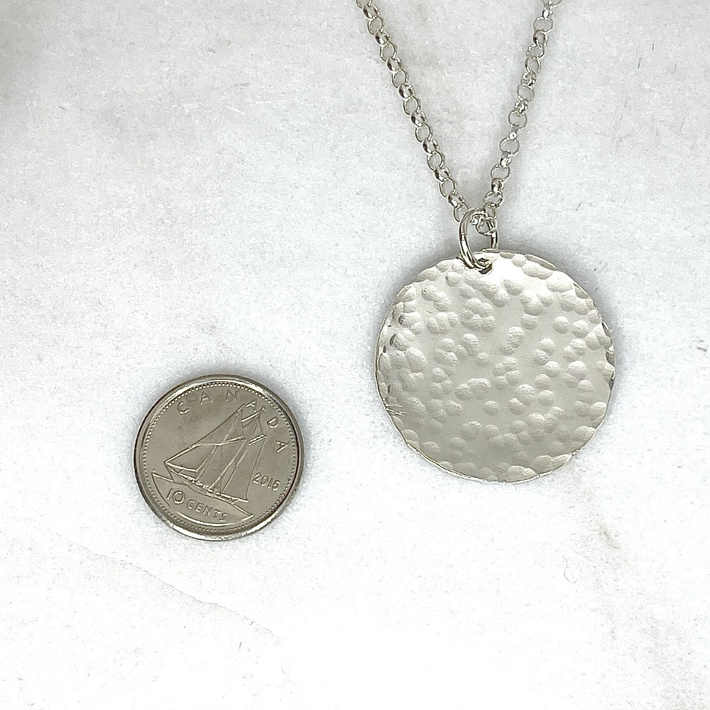 Hammered sterling silver round disk necklace on a long chain with a dime to show size reference