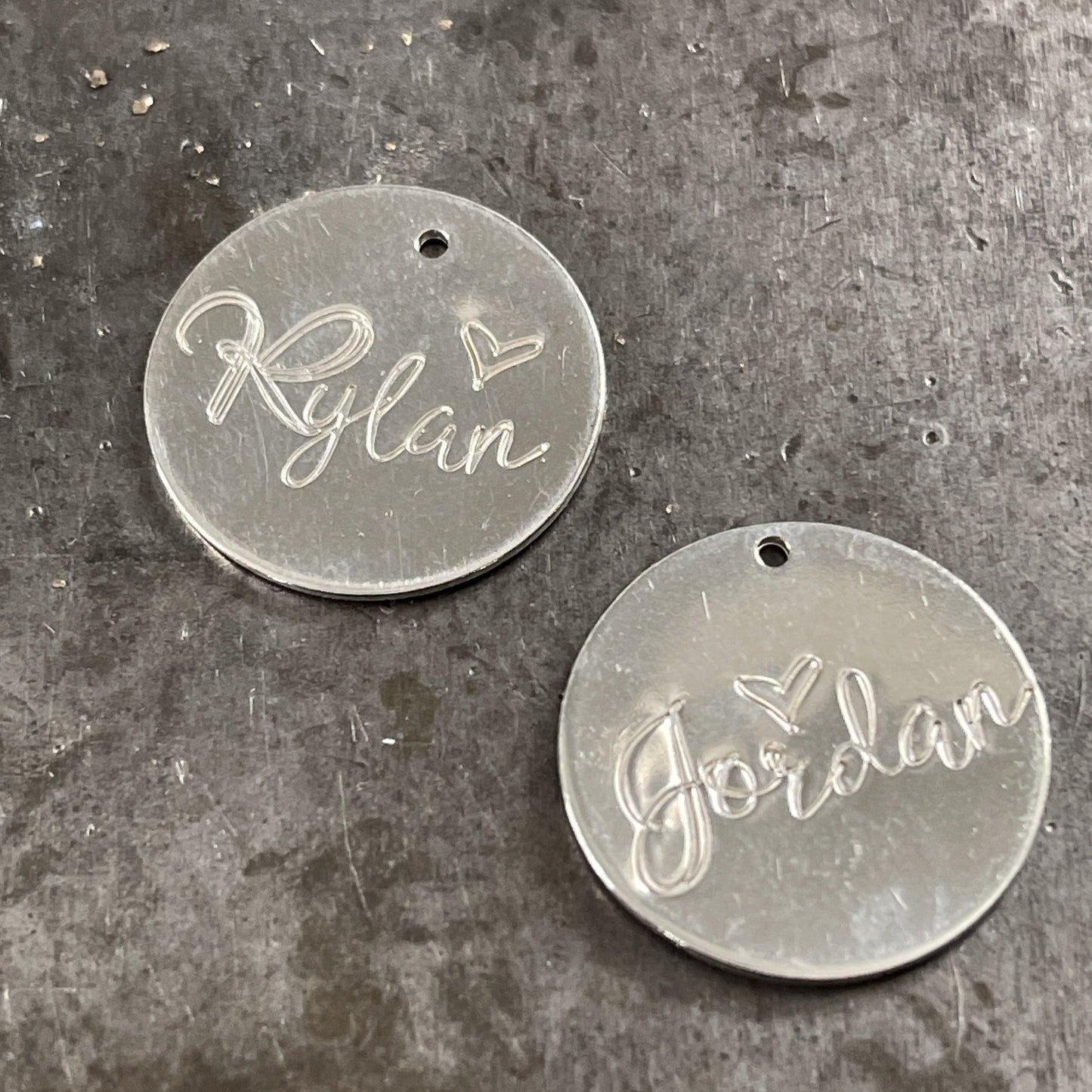 Shown is Among the Wildflowers script font hand stamped on sterling silver disks