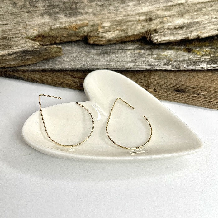 Teardrop shaped wire earrings in a heart shaped bowl.  Made of 14K Gold Fill. Minimal wire earrings.